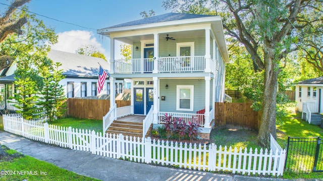 view of front of home featuring a balcony, a porch, ceiling fan, and a front yard