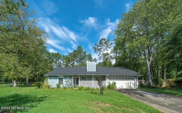 ranch-style home featuring a chimney, concrete driveway, a garage, and a front lawn