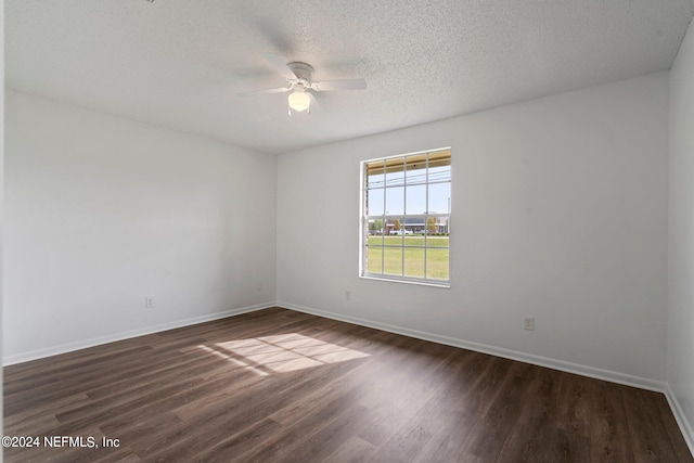 spare room featuring dark wood-style flooring, a textured ceiling, baseboards, and ceiling fan