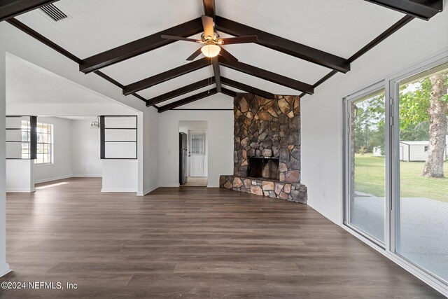 unfurnished living room featuring a ceiling fan, a fireplace, lofted ceiling with beams, dark wood-style floors, and visible vents