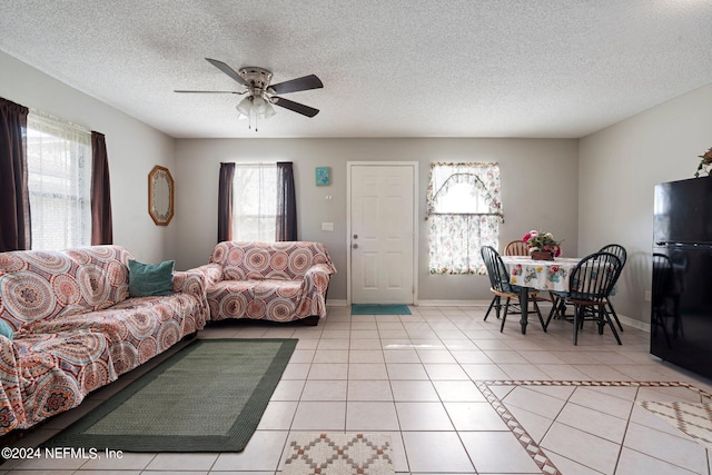 tiled living room featuring a textured ceiling and ceiling fan