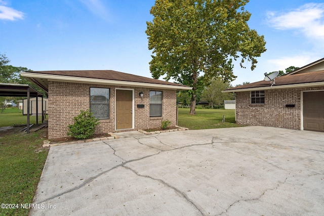 view of front of house featuring driveway, brick siding, and a front yard