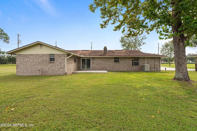 back of property featuring a patio, brick siding, central air condition unit, and a yard