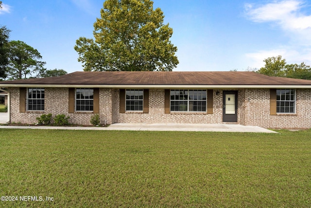 ranch-style house with brick siding, roof with shingles, and a front yard