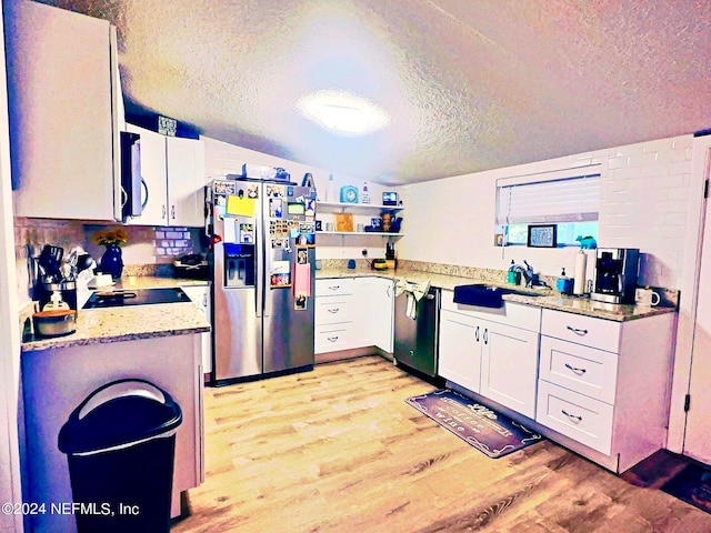 kitchen with light hardwood / wood-style floors, sink, lofted ceiling, white cabinetry, and stainless steel appliances