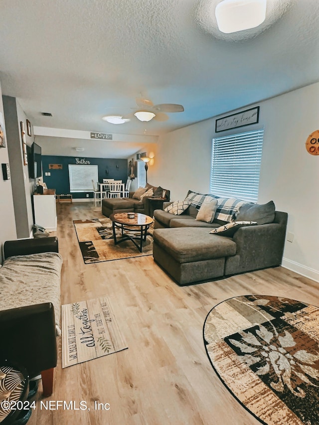 living room featuring a textured ceiling, ceiling fan, and hardwood / wood-style flooring