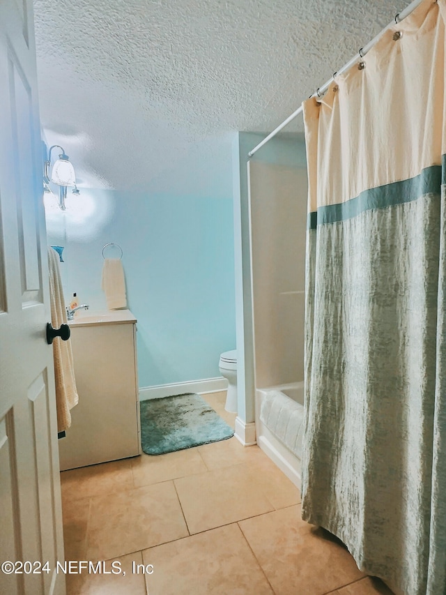 bathroom featuring a textured ceiling, toilet, a shower with shower curtain, and tile patterned floors