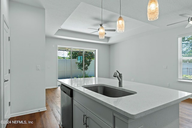 kitchen with ceiling fan, hanging light fixtures, sink, wood-type flooring, and dishwasher