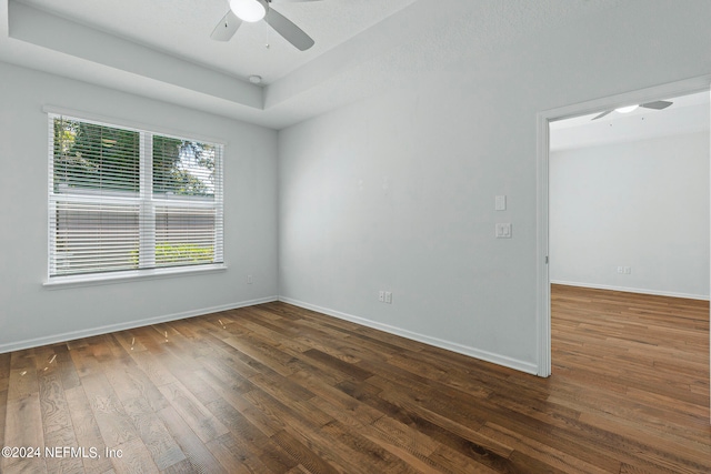 empty room with ceiling fan and dark hardwood / wood-style flooring