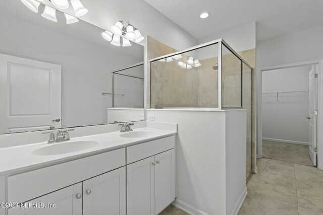 bathroom with tile patterned flooring, walk in shower, and vanity