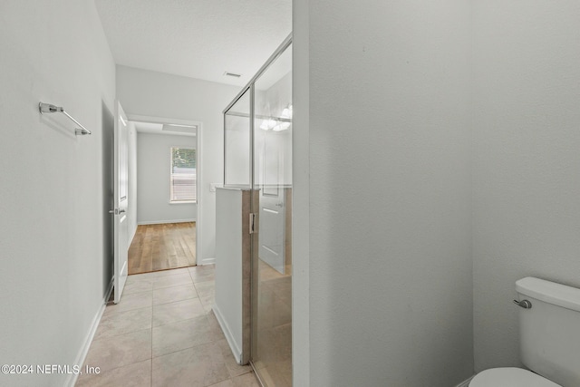 bathroom featuring tile patterned flooring, a textured ceiling, and toilet