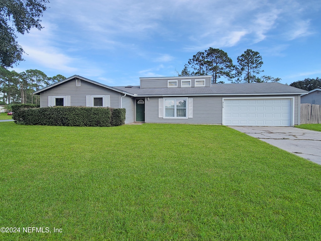 front facade featuring a front yard and a garage