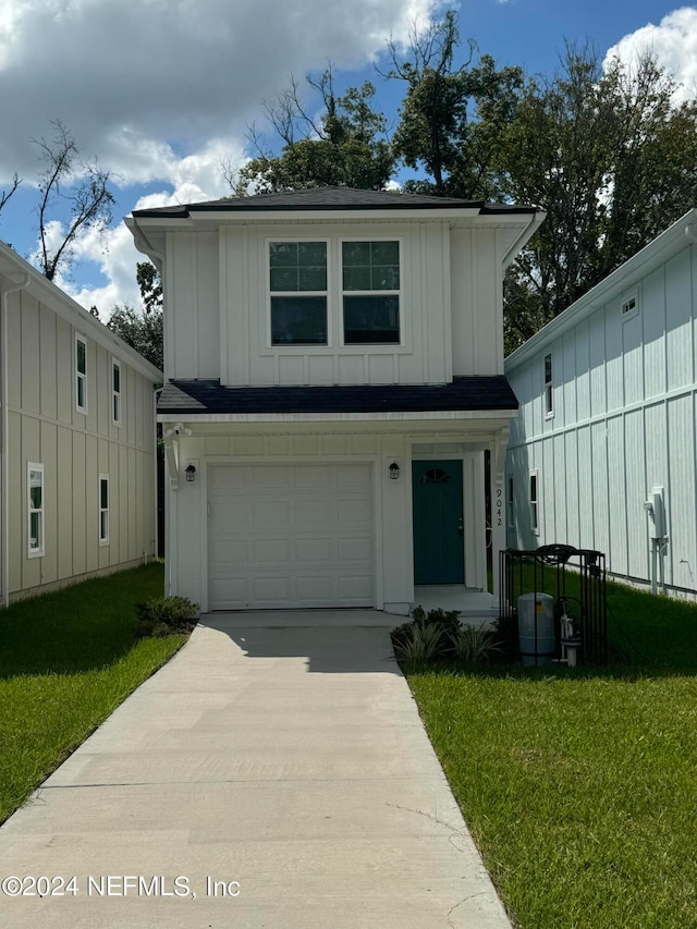 view of front of property with a front yard and a garage