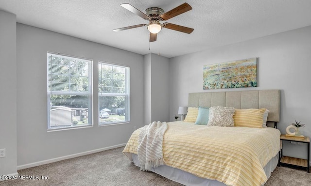 bedroom featuring ceiling fan, a textured ceiling, and light carpet