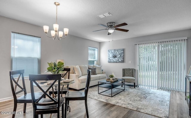 interior space with a textured ceiling, ceiling fan with notable chandelier, hardwood / wood-style floors, and a wealth of natural light