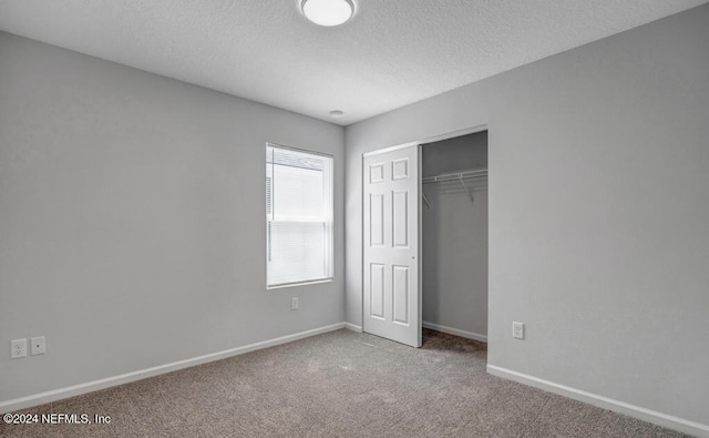 unfurnished bedroom featuring carpet, a closet, and a textured ceiling