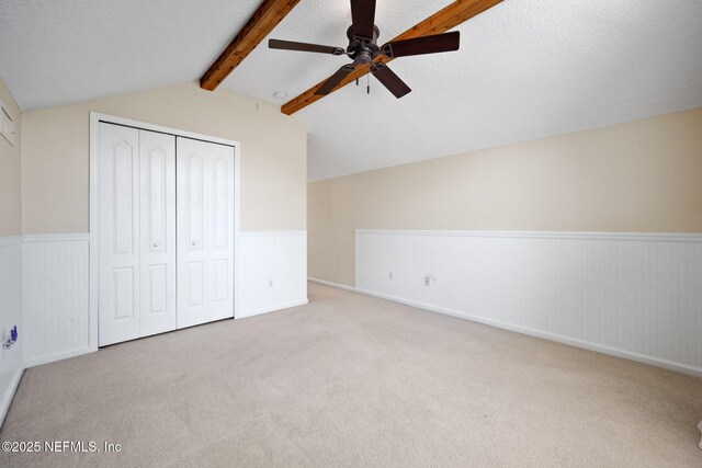 96316 Ridgewood Cir, Fernandina Beach, FL 32034 - unfurnished bedroom featuring a wainscoted wall, a closet, carpet, a textured ceiling, and a ceiling fan