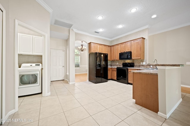 96316 Ridgewood Cir, Fernandina Beach, FL 32034 - kitchen with black appliances, washer / clothes dryer, a chandelier, a peninsula, and crown molding