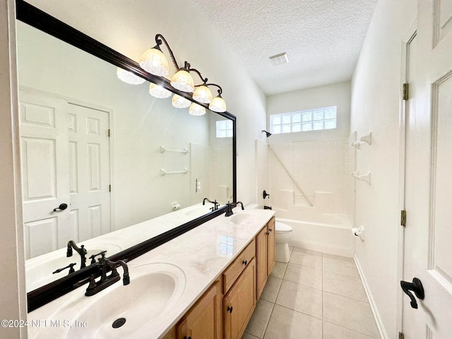 full bathroom featuring vanity, tile patterned floors, tiled shower / bath, toilet, and a textured ceiling