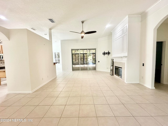 unfurnished living room featuring a textured ceiling, ceiling fan, light tile patterned flooring, and crown molding