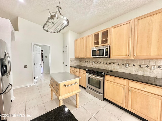 kitchen featuring light tile patterned floors, light brown cabinetry, backsplash, and appliances with stainless steel finishes