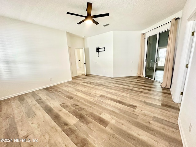 empty room featuring ceiling fan, a textured ceiling, and light hardwood / wood-style flooring