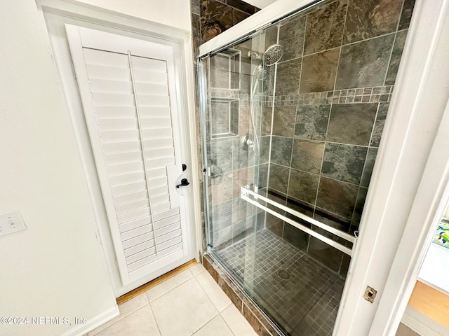 bathroom featuring tile patterned floors and a shower with shower door