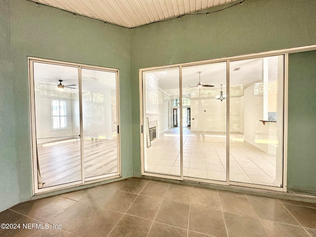 interior space with tile patterned floors, ceiling fan, and wood ceiling