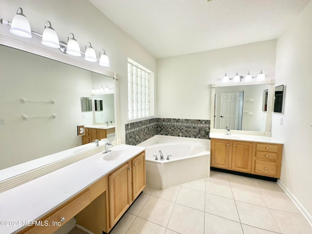 bathroom with tile patterned floors, a tub, vanity, and a textured ceiling