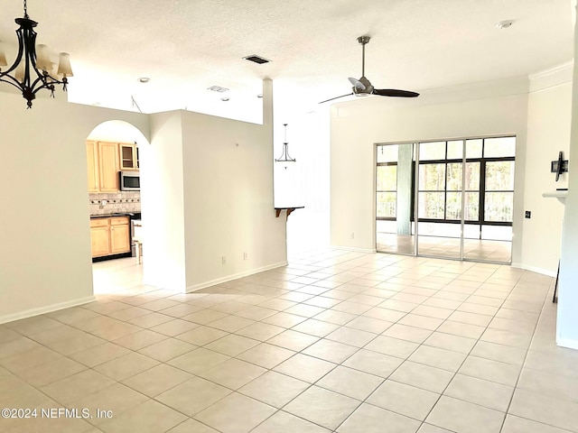 spare room featuring a textured ceiling, light tile patterned flooring, and ceiling fan with notable chandelier