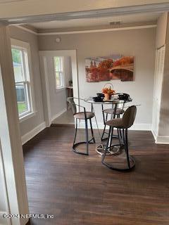 dining room featuring ornamental molding and dark hardwood / wood-style flooring