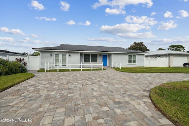 single story home featuring a garage and a front lawn