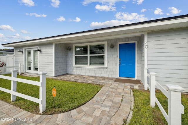 entrance to property with a lawn