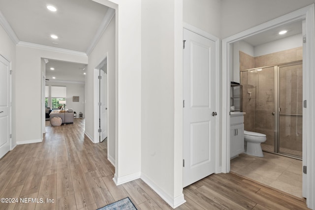 hallway with crown molding and light hardwood / wood-style floors