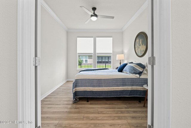 bedroom with wood-type flooring, ceiling fan, and crown molding