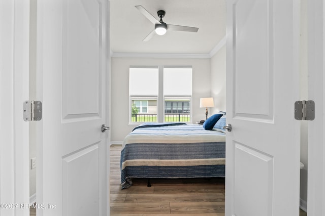 bedroom featuring wood-type flooring, ceiling fan, and crown molding