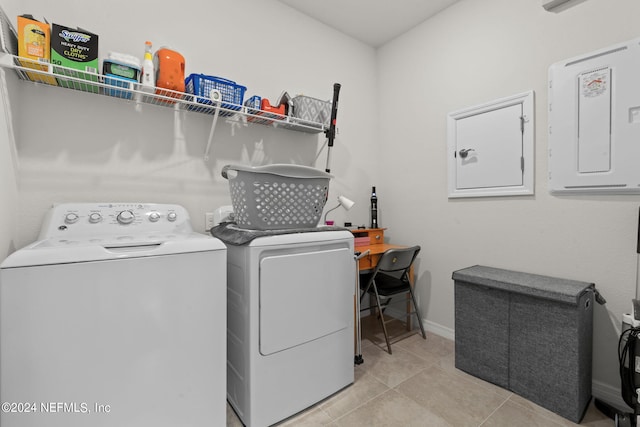 laundry area featuring light tile patterned floors, electric panel, and washer and clothes dryer