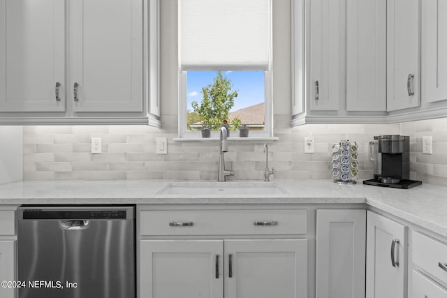 kitchen featuring backsplash, stainless steel dishwasher, sink, and white cabinets