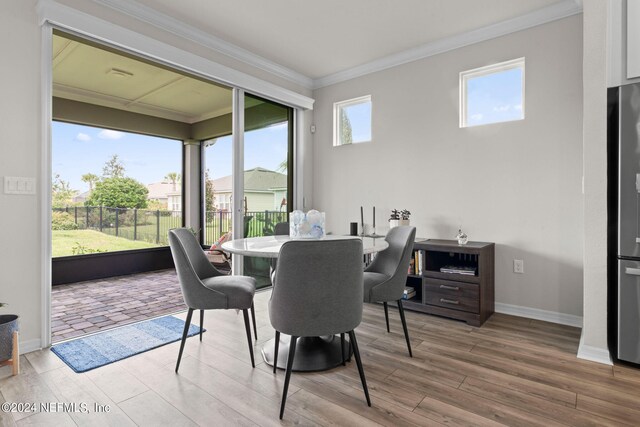 dining space featuring ornamental molding and wood-type flooring