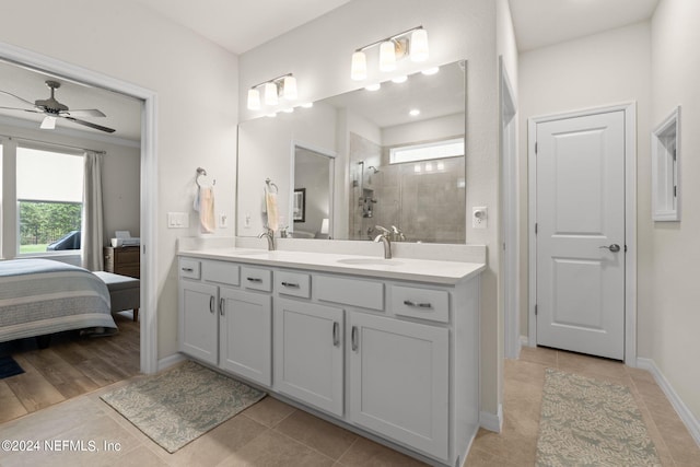 bathroom with tiled shower, vanity, ceiling fan, and tile patterned floors