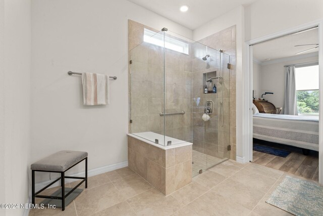 bathroom with tile patterned flooring, ceiling fan, a shower with door, and crown molding