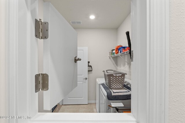 laundry area with light tile patterned flooring and washing machine and dryer