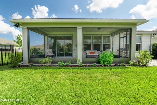 back of house with a sunroom and a yard