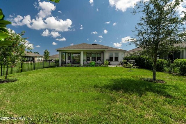 rear view of house featuring a lawn