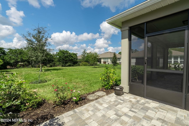 view of yard featuring a sunroom and a patio