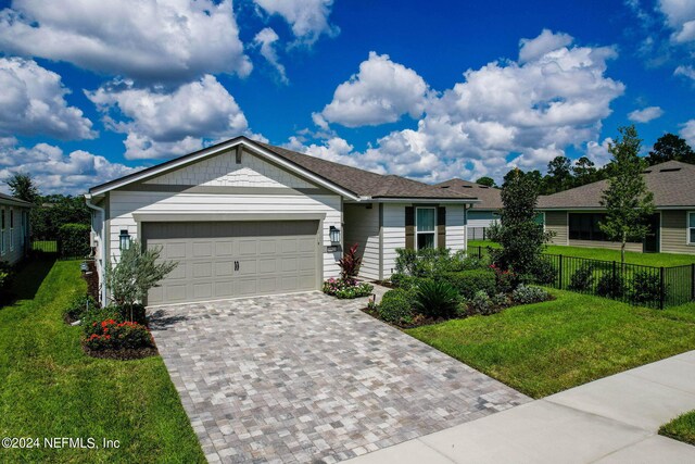 ranch-style house featuring a garage and a front lawn