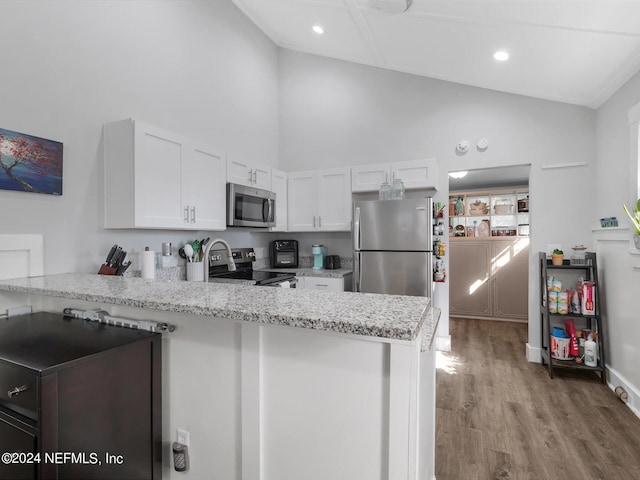 2745 Gilmore St, Jacksonville, FL 32205 - kitchen featuring white cabinets, a peninsula, light wood-style floors, high vaulted ceiling, and appliances with stainless steel finishes