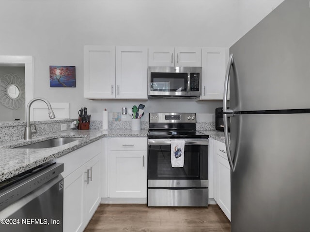 2745 Gilmore St, Jacksonville, FL 32205 - kitchen featuring white cabinets, light stone counters, a sink, and appliances with stainless steel finishes
