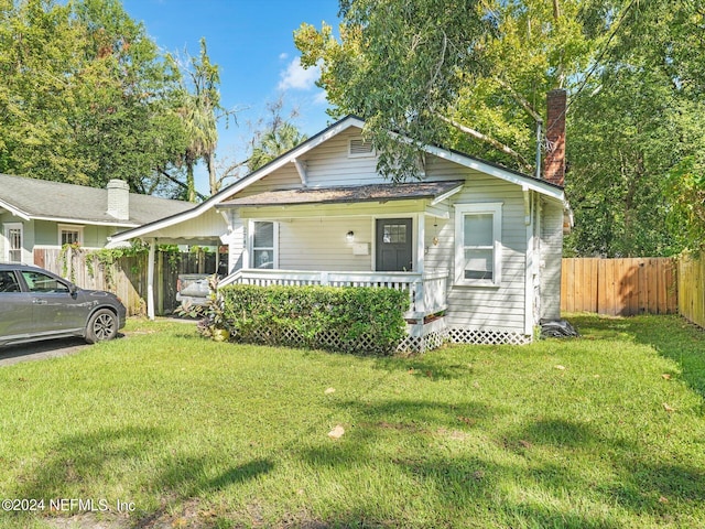 2745 Gilmore St, Jacksonville, FL 32205 - bungalow-style home with fence, a front lawn, covered porch, and a chimney