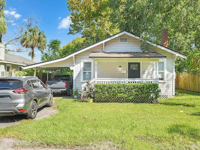 2745 Gilmore St, Jacksonville, FL 32205 - bungalow-style home with a chimney, fence, a front lawn, an attached carport, and a porch